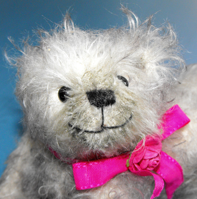 Reclining bear with ribbon